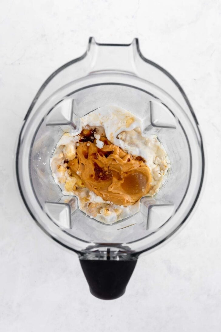 cashews, coconut milk, peanut butter, and maple syrup inside a vitamix belnder