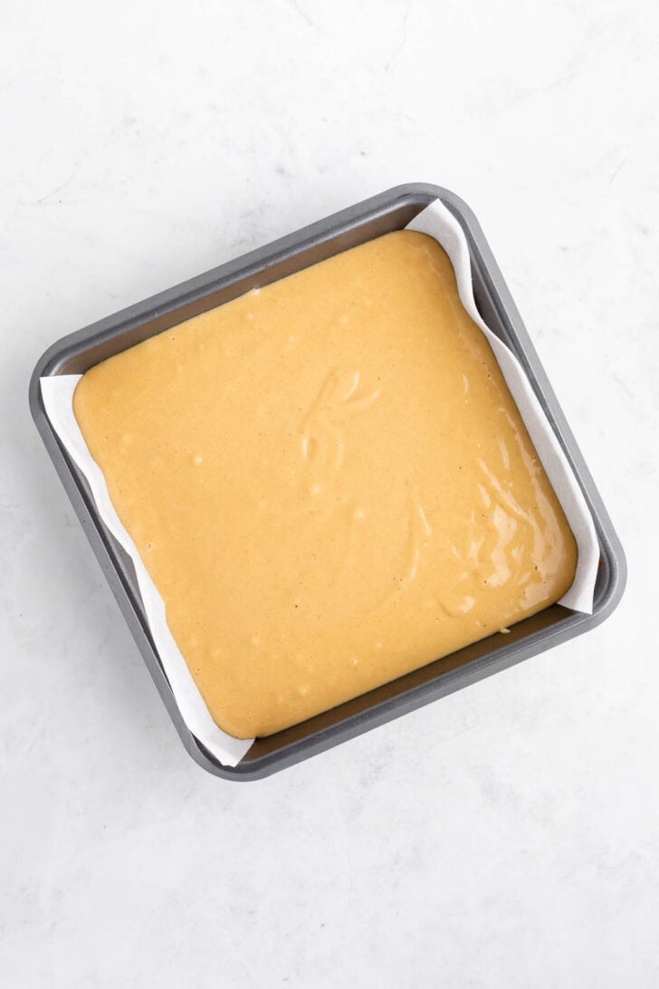 no-bake peanut butter cheesecake filling spread over graham cracker crust inside a baking dish